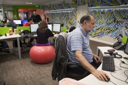 Trabajadores de Globant, algunos sentados en pelotas ergon&oacute;micas.