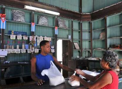 Un bodeguero vende productos racionados a una clienta, ayer en La Habana.