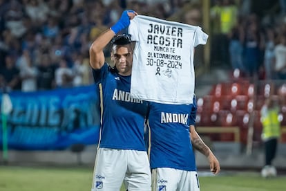 Radamel Falcao celebra su primer gol con el equipo Millonarios FC sosteniendo una camiseta con un mensaje en honor a Javier Acosta, en Bogotá, el 1 de septiembre de 2024.