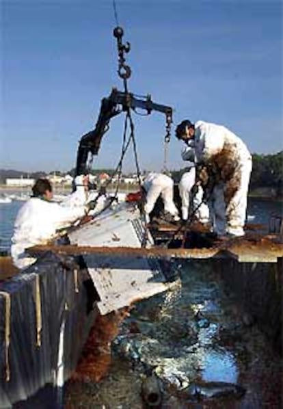 Un grupo de voluntarios descarga un contenedor de fuel procedente de las Islas Ons en el puerto de Portonovo (Pontevedra).