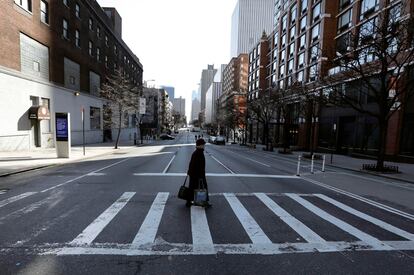 Una mujer cruza una calle en Nueva York.