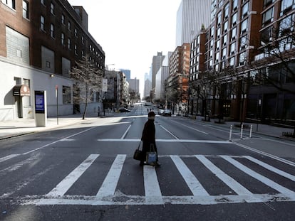 Una mujer cruza una calle en Nueva York.