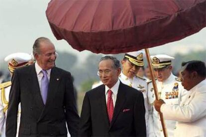 Don Juan Carlos conversa con el rey de Tailandia, Bhumibol Adulyadej, a su llegada a Bangkok.