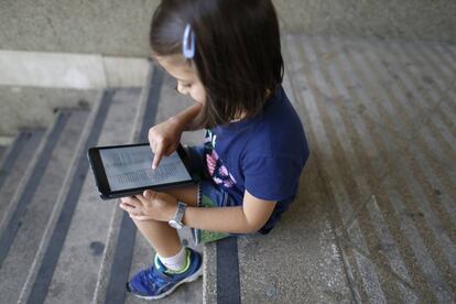 Una niña lee en una tableta digital.