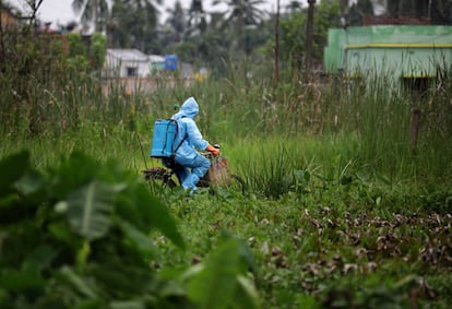 Un trabajador municipal se traslada en bicicleta para desinfectar una zona contaminada por coronavirus cerca de Calcuta (India). La pandemia ha registrado en las últimas 24 horas en India 48.513 nuevos casos y 768 muertos, lo que eleva el total a más de 1,5 millones de personas contagiadas y más de 34.000 víctimas mortales, según ha informado el Ministerio de Sanidad indio.