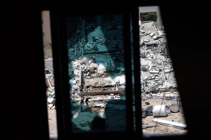 Dos hombres retiran escombros en el barrio de AlvRimal de la ciudad de Gaza (Palestina). El Ejército de Israel ha asegurado que el Movimiento de Resistencia Islámica (Hamás) operaba desde la torre Al Yalá, que acogía sedes de medios de comunicación internacionales y que fue derribada en un bombardeo israelí, para intentar afectar las operaciones del sistema antiaéreo 'Cúpula de Hierro'.