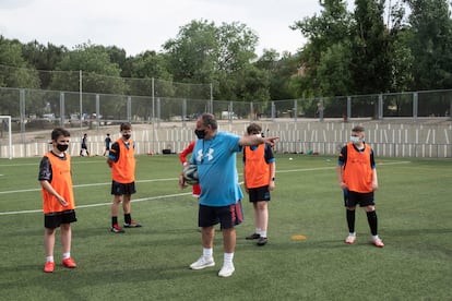 Un entrenador da instrucciones a sus jugadores durante el entrenamiento de infantiles del Santiago Apóstol.