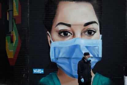 Un hombre camina frente a un mural recién pintado en Londres como homenaje al personal sanitario.