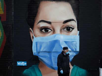 Un hombre camina frente a un mural recién pintado en Londres como homenaje al personal sanitario.