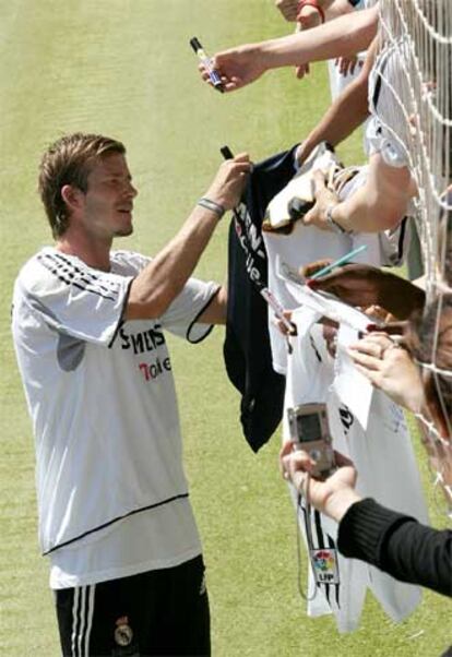 Beckham firma autógrafos tras un entrenamiento del Madrid en Las Rozas.