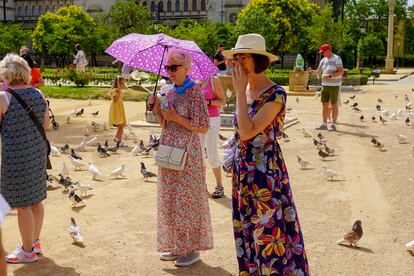 Una turista con paraguas el parque de Maria Luisa este domingo, en el primer día de la ola de calor.