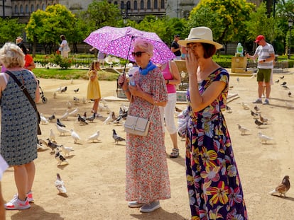Una turista con paraguas el parque de Maria Luisa este domingo, en el primer día de la ola de calor.