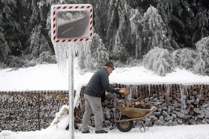 Las autoridades han pedido a la población que no beba agua corriente por el temor de que pueda estar contaminada ya que los cortes de energía han afectado a las plantas de depuración. En la imagen, un hombre carga leña en una carretilla en Prestranek (Eslovenia), 4 de febrero de 2014.