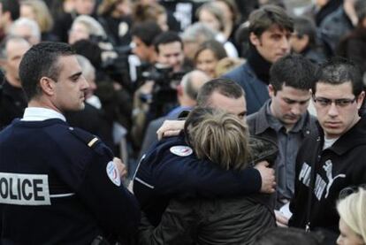 Familiares y compañeros del policía asesinado por ETA en Dammarie-lès-Lys se abrazan durante un acto en su memoria en esa localidad.