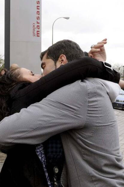 Dos empleados del Grupo Marsans celebran el primer premio del sorteo de la lotería junto a la sede de la compañía de viajes.