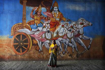 Una votante, ante un mural con una escena del Mahabharata, en Uttar Pradesh.