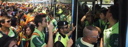 Decenas de jóvenes tratan de subir a un autobús de la EMT en Aluche para llegar al aeródromo de Cuatro Vientos.