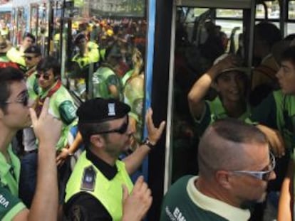 Decenas de jóvenes tratan de subir a un autobús de la EMT en Aluche para llegar al aeródromo de Cuatro Vientos.