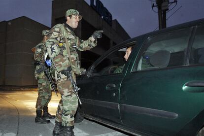 Un soldado chileno habla con el donductor de un vehículo durante una patrulla , tras el despliegue militar ordenado por el Gobierno.