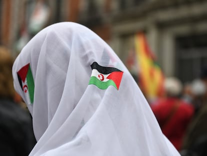 Una manifestante con un pañuelo blanco, con banderas saharauis, en una manifestación convocada por la Coordinadora Estatal de Asociaciones Solidarias con el Sáhara (CEAS-Sáhara), frente al Ministerio de Asuntos Exteriores, a 26 de marzo de 2022, en Madrid (España).