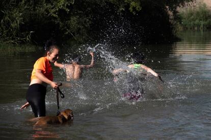 Unos jóvenes se bañan en el Rio Segre a su paso por Lleida, ciudad afectada por la ola de calor más intensa en un mes de junio en Cataluña.