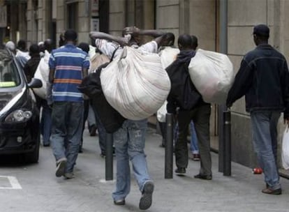 Un grupo de subsaharianos, vendedores ambulantes, por La Rambla de Barcelona.