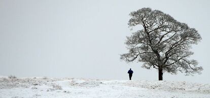 Un hombre corre sobre la nieve del parque Lyme, en Stockport.