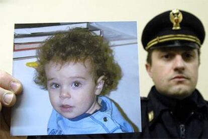 Un policía italiano muestra ayer en Parma la foto del pequeño Tommaso Onofri.