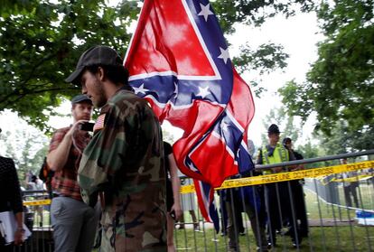 Um supremacista branco leva a bandeira confederada.