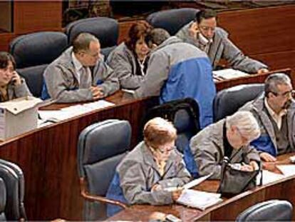 Diputados de IU, ayer, en la Asamblea de Madrid, vestidos de obreros para apoyar a los trabajadores de Sintel.