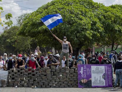 Um jovem levanta uma bandeira da Nicarágua sobre uma barricada, em 21 de abril de 2018, durante o quarto dia de protestos em Manágua (Nicarágua).