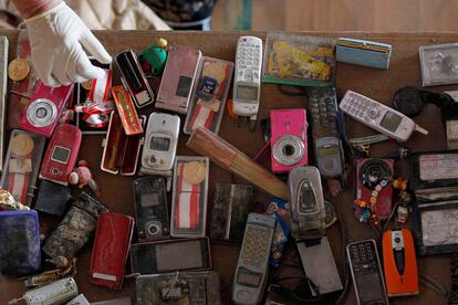 Teléfonos móviles y otros objetos, dispuestos en un centro donde se disponen las objetos recuperados entre los escombros tras el terremoto y el tsunami del 11 de marzo.