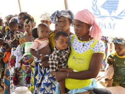 Mujeres y niños hacen cola en un campamento de Burkina Faso.