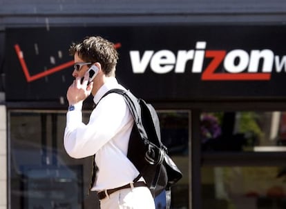 Un hombre habla por tel&eacute;fono ante una tienda de Verizon.