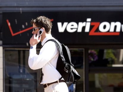 Un hombre habla por tel&eacute;fono ante una tienda de Verizon.