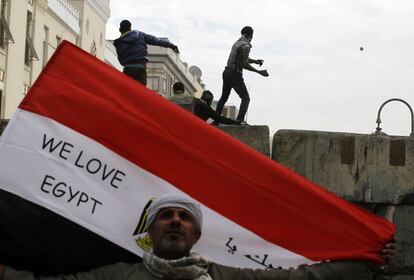Un manifestante sujeta la bandera de su país durante los enfrentamientos de manifestantes y policías durante el segundo aniversario de la revolución egipcia en la plaza de Tahrir del Cairo.