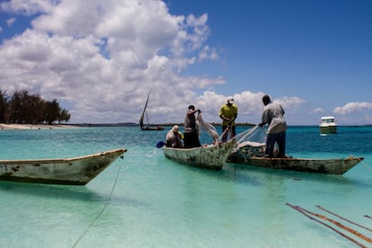 A pesar de los esfuerzos del Gobierno, el sector turístico tiene pocos vínculos con la economía local y, por tanto, un impacto limitado en la reducción de la pobreza. La pesca es otra de las principales actividades económicas. Los pescadores se benefician del turismo porque pueden vender más mercancia a los hoteles . En la imagen, cuatro pescadores recogen amarras tras un día de trabajo en Nungwi.