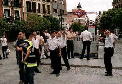 Policías y vigilantes privados prohibían ayer el acceso a una de las bocas de metro de Lavapiés.