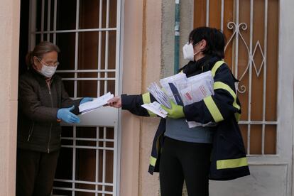 Una trabajadora de Correos reparte las mascarillas por los domicilios de Terrrassa, este mircoles.