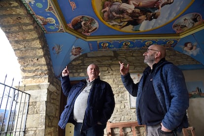 El alcalde de Latre, Primitivo Grasa, y un vecino en la iglesia de San Miguel, frente a la imagen de San Martín con la cara del empresario Eduardo Lacasta.