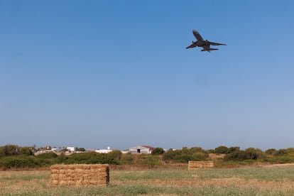 Uno de los aviones despega en la base de Rota bajo el campo de trigo ya recogido.