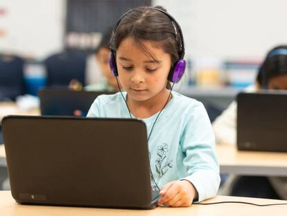 Un grupo de niños usa recursos informáticos en clase.