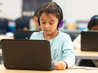Un grupo de niños usa recursos informáticos en clase.