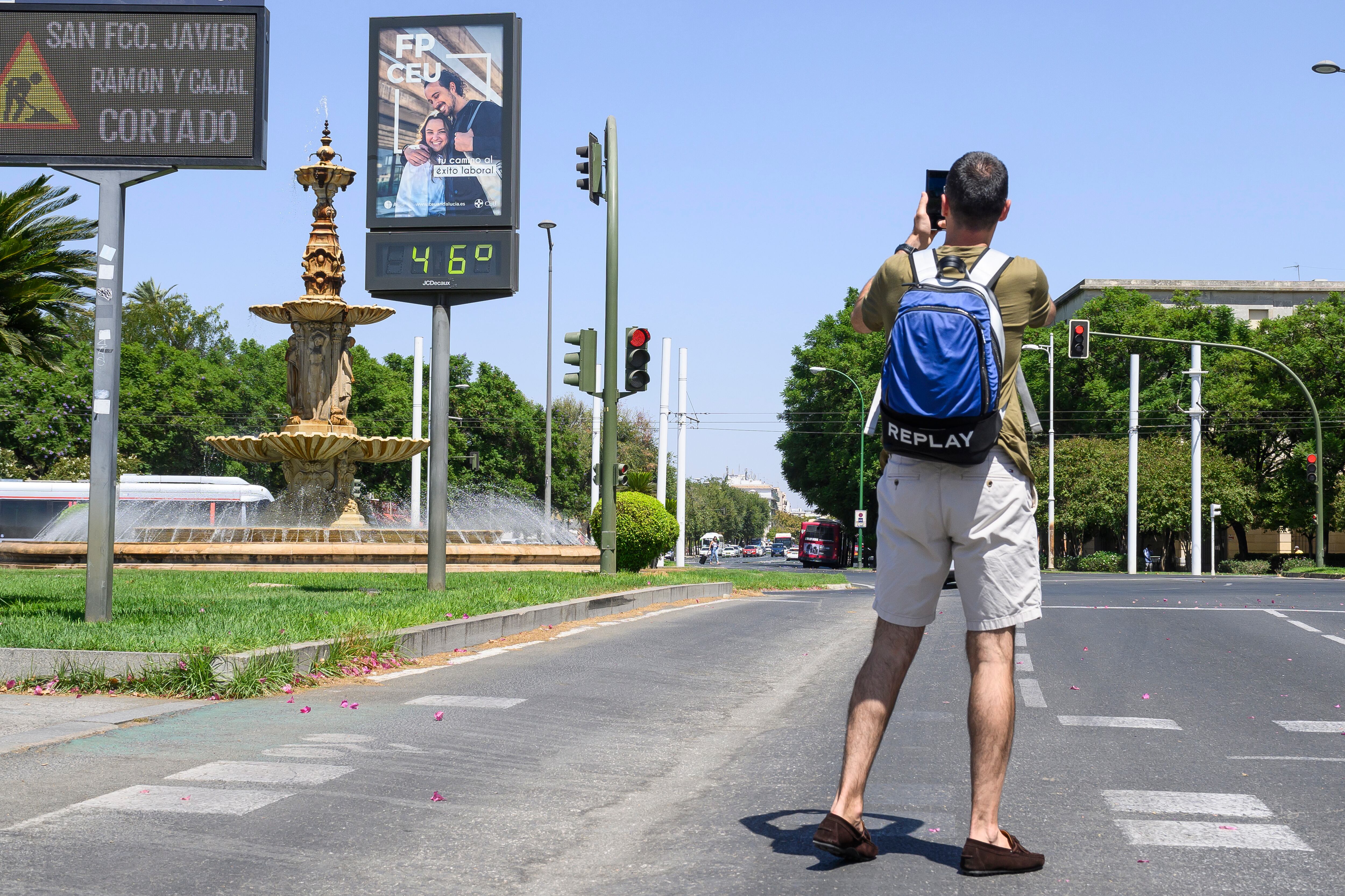 Un joven fotografía un termómetro en el centro de Sevilla, este martes.