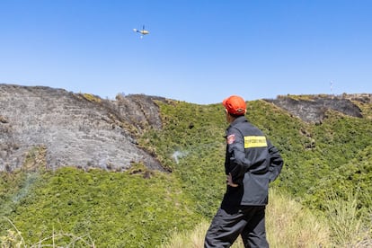 Konstantinos Stratigos, bombero local de Corfú, observaba dónde ha descargado agua un helicóptero para darle indicaciones.