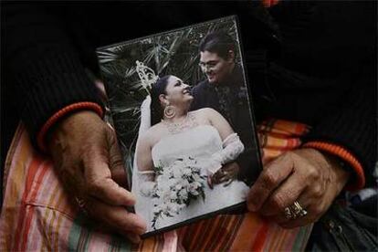 Las manos de 65 años de Lola Fernández sostienen la foto de boda gitana de unos vecinos, antes casados por lo civil. Una generación abre paso a la que establecerá otro modo de ser gitano.