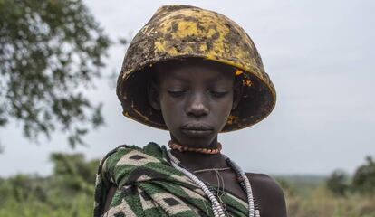 En la imagen, una niña del poblado mursi de Marreke en el Parque Nacional de Mago posa vestida con una manta de tejido sintético y un casco de obrero procedente de la cercana construcción de una planta azucarera.