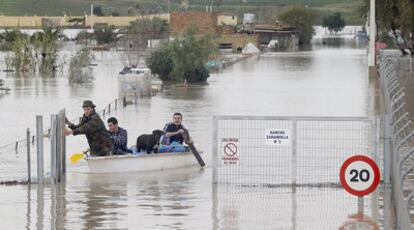 Vecinos de Rancho de Zarandilla, en Jerez (Cádiz), acceden a sus viviendas en una barca.