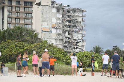 Grupo observa os danos causados ​​no prédio.