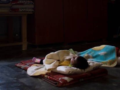 Dos niños duermen la siesta sobre unas mantas colocadas en el suelo de una vivienda del asentamiento temporal de Hauch er-Rafqa, en Líbano.